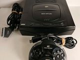 a video game system sitting on a table next to a charger