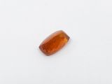 an orange sapphire stone on a white surface