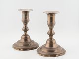 pair of antique brass candlesticks on a white background