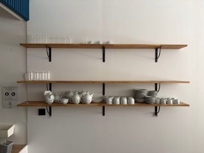 plusieurs étagères sur lesquelles sont posées des assiettes et des tasses dans la cuisine