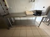 une table en acier inoxydable sur laquelle se trouvent une pile de papiers