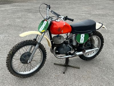 une moto tout-terrain rouge et verte garée sur un parking