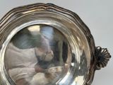 a silver plate with a reflection of a person in it