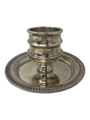 an antique silver plate with a candle holder on it