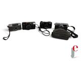 three cameras sitting next to each other on a white surface