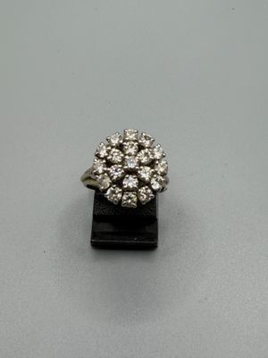 un gros plan d'une bague en diamant posée sur un socle noir