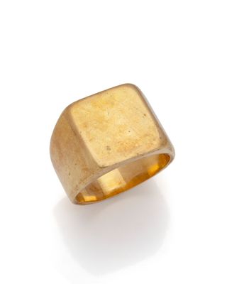 a close up of a gold ring on a white surface