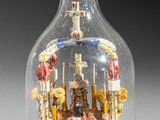 a glass bottle with a miniature ship inside of it