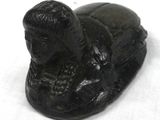 a black statue of a man laying down on a white surface