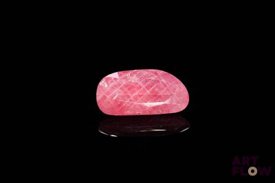 un quartz rose posé sur une surface noire
