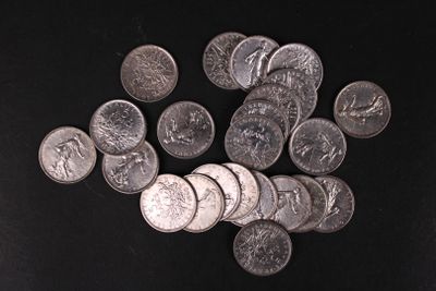 a pile of silver coins on a black surface