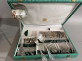 un coffret vert contenant de l'argenterie sur une table