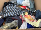 a cardboard box filled with clothes and other items