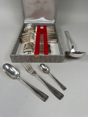une boîte contenant des couverts et des cuillères, posée sur une table