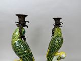 two green parrots sitting on top of each other