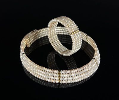 a pair of pearl bracelets on a black surface