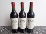 trois bouteilles de vin posées sur une table l'une à côté de l'autre