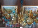 une étagère en verre sur laquelle sont posés de nombreux objets en verre