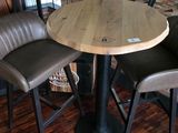 leather bar stools and a round wooden table in a restaurant