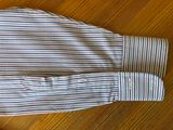 striped dress shirt on a wooden table next to a pair of scissors