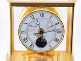 a gold clock with a white face and a black face
