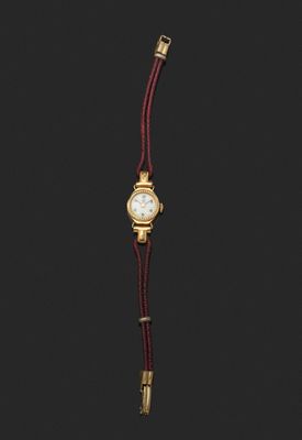 une montre-bracelet pour femme avec un boîtier plaqué or et un bracelet en cuir rouge