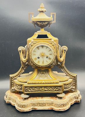 a gold clock sitting on top of a table