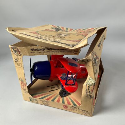 un petit avion miniature dans une boîte en carton posée sur une table