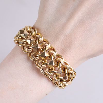gold plated chain bracelet with pyramids on a woman ' s wrist