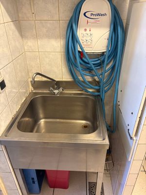 un lavabo muni d'un tuyau d'arrosage dans une salle de bains