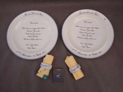 two white plates with writing on them on a table