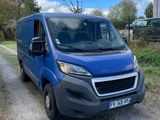 the blue van is parked on the side of a dirt road