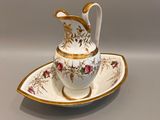 une tasse et une soucoupe blanches et dorées posées sur une soucoupe
