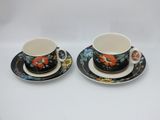two cups and saucers with floral designs on them
