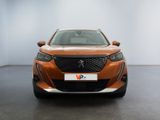 a close up of the front of a orange car in a room