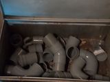 a metal box full of pipes and fittings in it