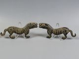 Deux figurines de chevaux sont placées l'une à côté de l'autre sur une surface blanche.