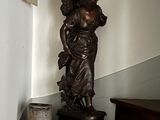 a statue of a woman holding a basket on a table