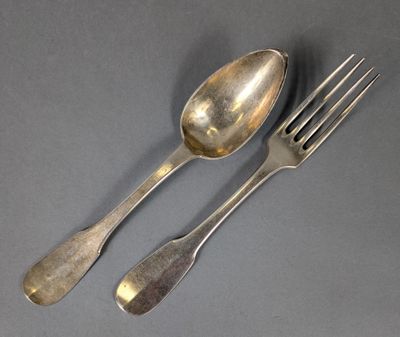 deux cuillères et une fourchette en argent sur une surface grise