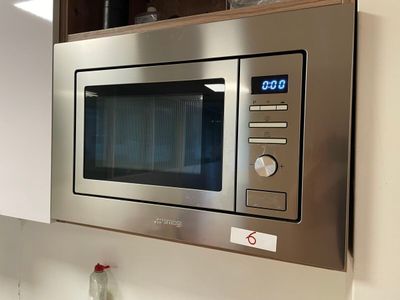 a stainless steel microwave with a digital clock on it