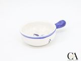 a small white bowl with a blue handle on a white surface