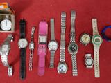 a lot of watches that are sitting on a red surface