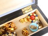 une boîte en bois remplie d'un assortiment de boutons et de broches