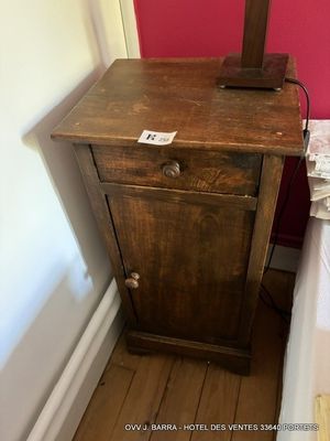 une petite table sur laquelle est posée une lampe, dans un coin de la pièce