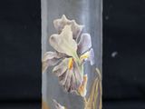 a glass vase with a flower on it on a black surface