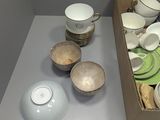 a box full of white and green dishes on a table