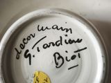 a white plate with writing on it with a yellow sticker on it