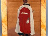 an old picture of a man in a red coat and white cape