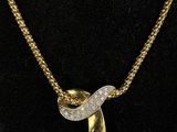 a gold and diamond necklace on a mannequin neck