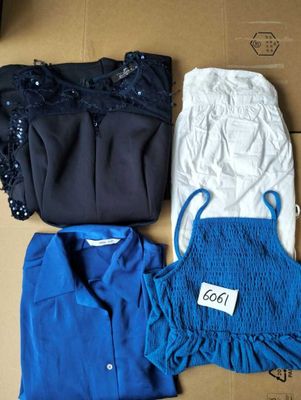 three shirts and a skirt are sitting on a cardboard box